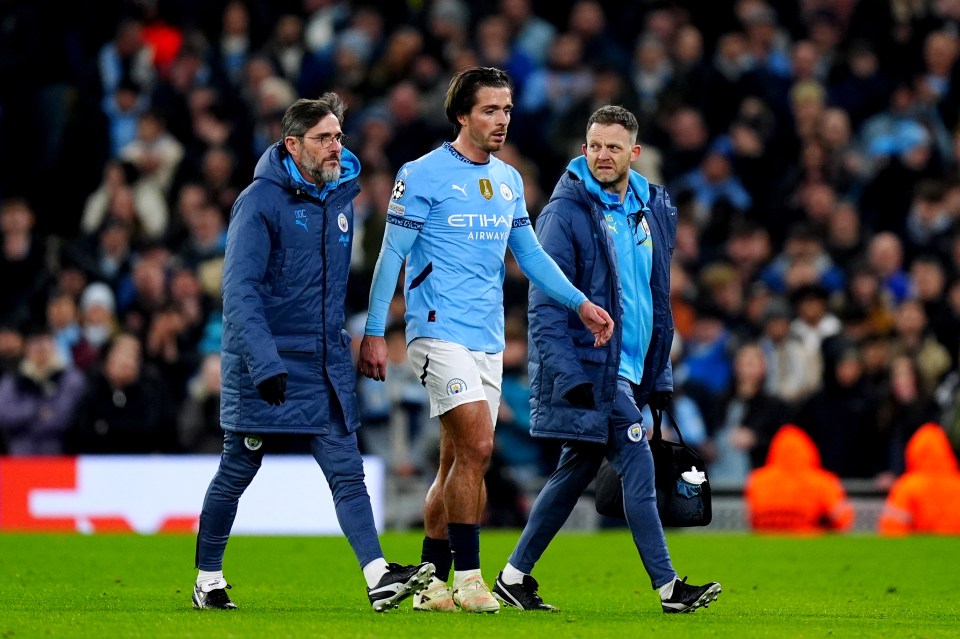 Jack Grealish of Manchester City being escorted off the field by medical staff.