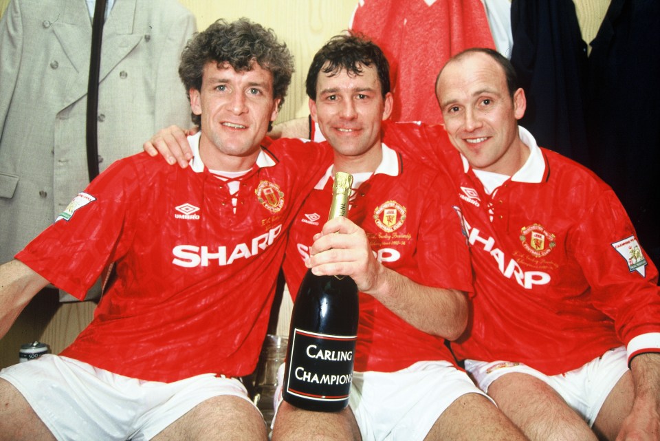 Manchester United players Mark Hughes, Bryan Robson, and Mike Phelan celebrating with champagne after winning the FA Carling Premiership.