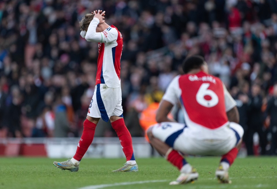 Arsenal's Odegaard and Magalhaes look dejected after a soccer match.