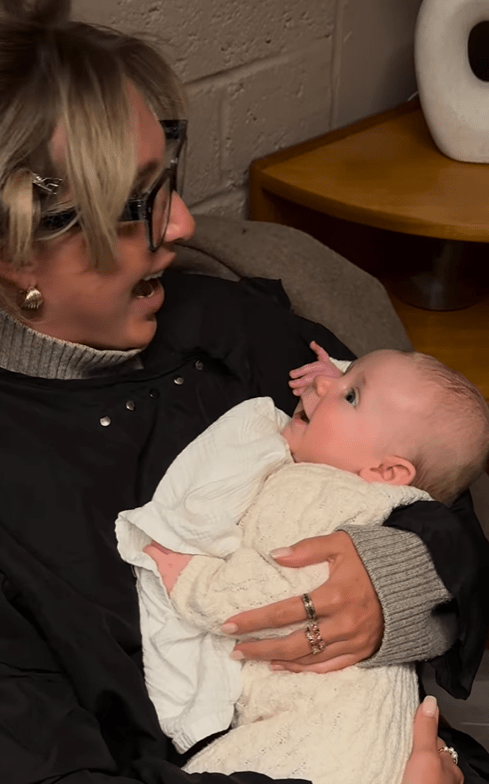 Woman holding and interacting with a baby.