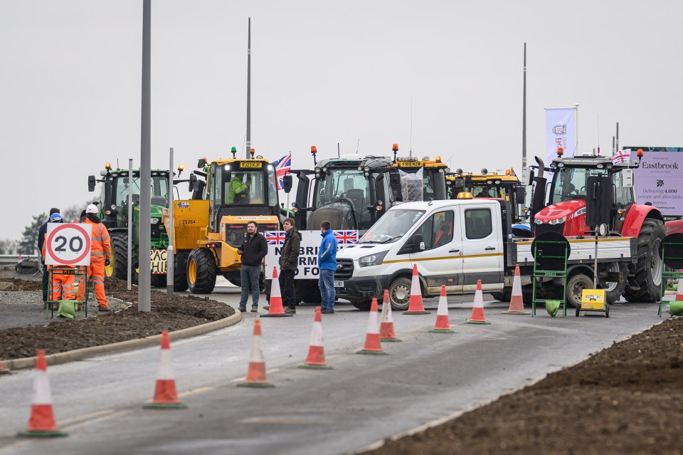 Farmers protesting roadblock near housing development.