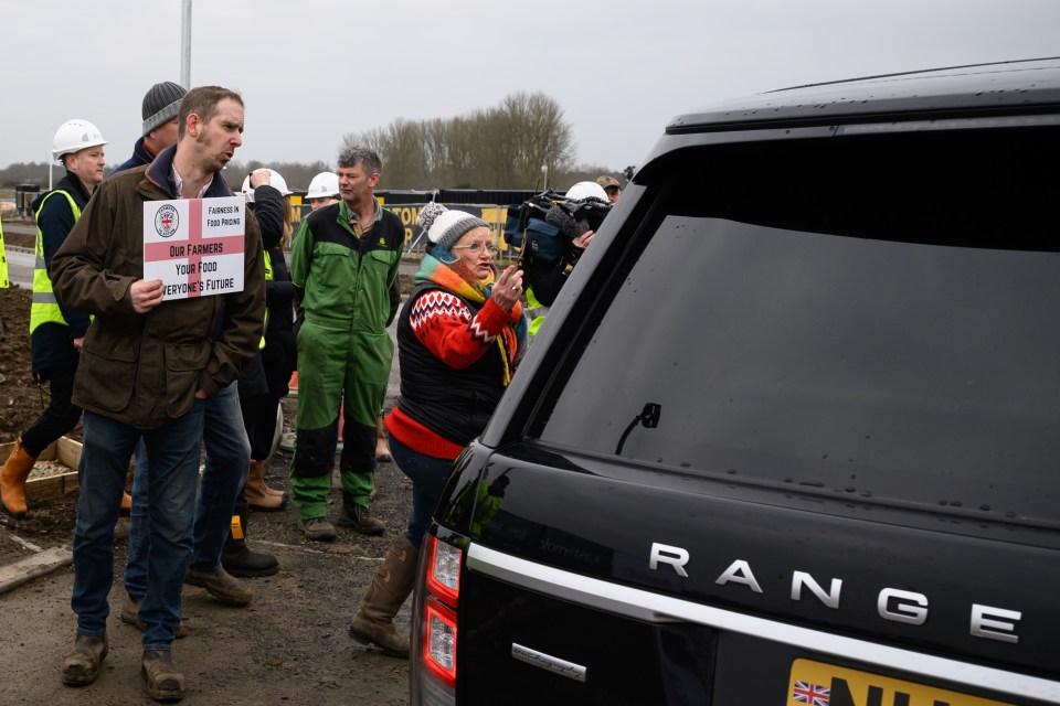 Farmers protesting near a car carrying the Prime Minister.