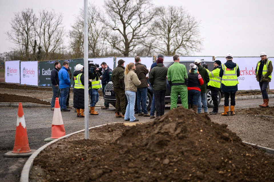 Farming protesters surrounding a car carrying the Prime Minister at a housing construction site.