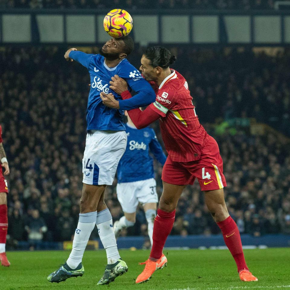 Everton's Beto and Liverpool's Virgil van Dijk contesting a header during a Premier League match.