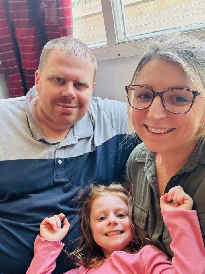 Photo of a family: a man, woman, and young girl.