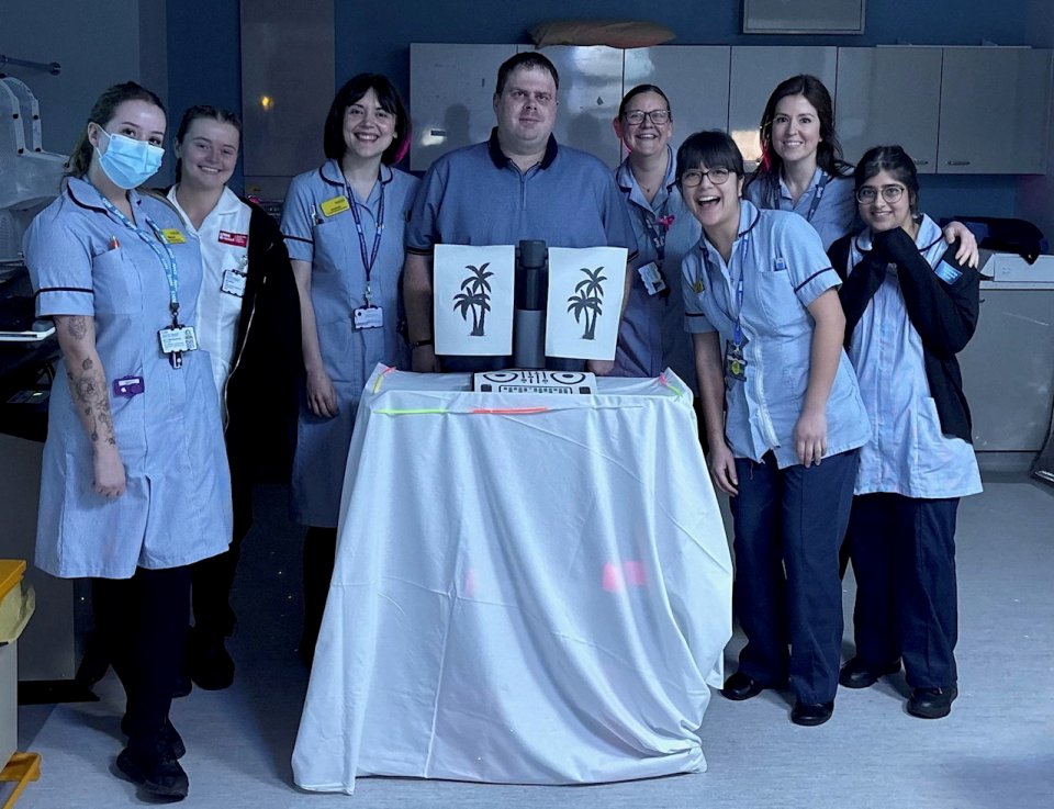 NHS staff with a patient celebrating his recovery from a brain tumour.