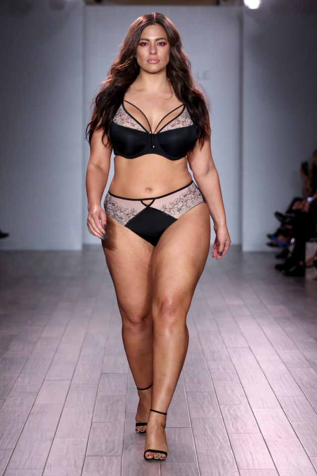 Ashley Graham walking a runway in lingerie.