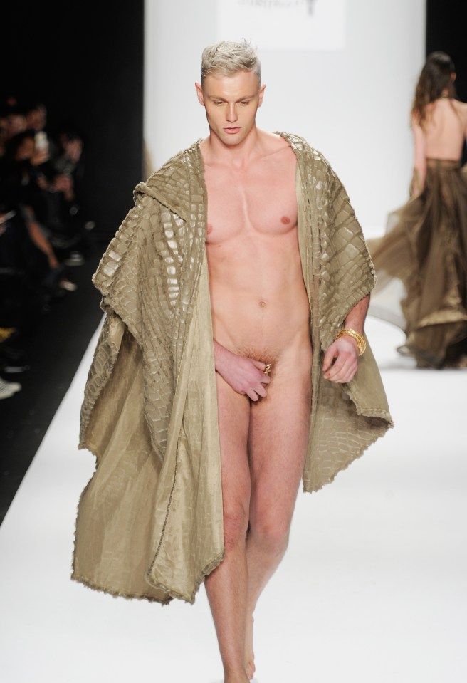 Male model walking a runway, wearing a tan textured robe.