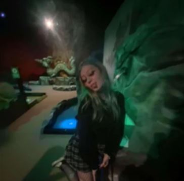 Woman posing at a miniature golf course.