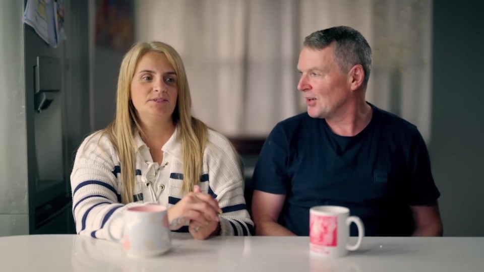 A woman and a man sitting at a table, talking.