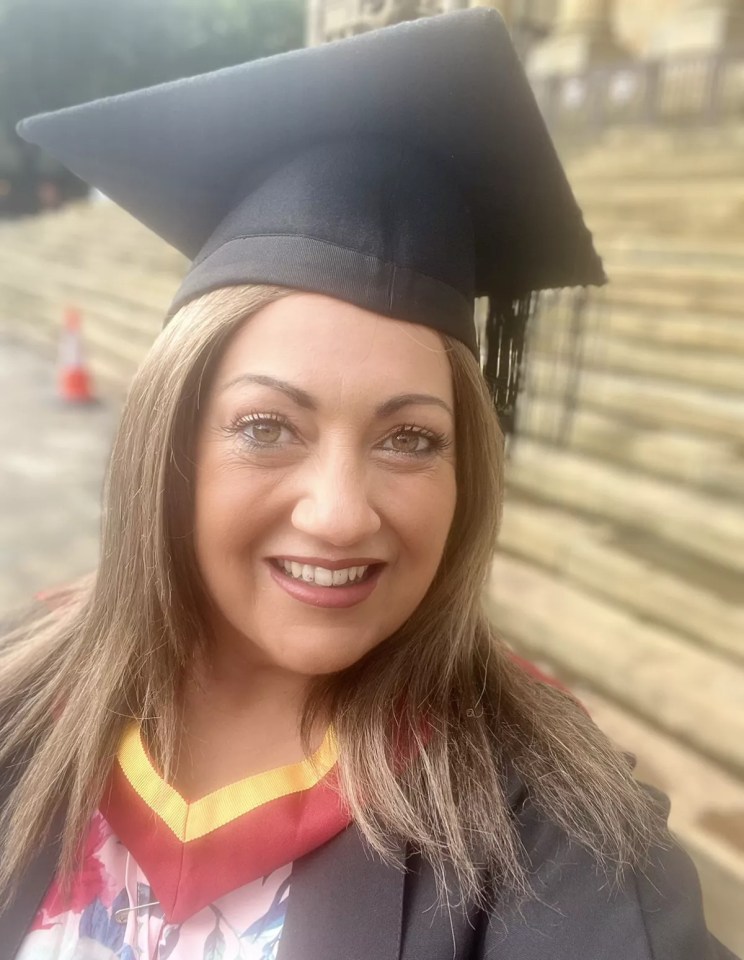 A smiling woman wearing a graduation cap and gown.