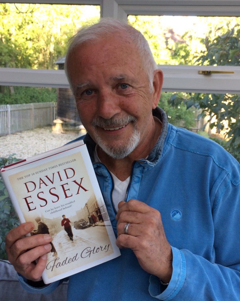 David Essex holding his book, *Faded Glory*.