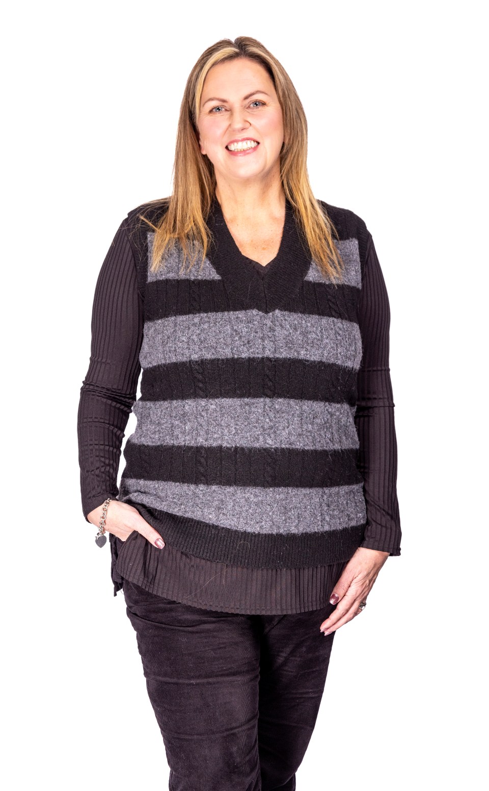 Woman smiling and wearing a striped sweater vest.