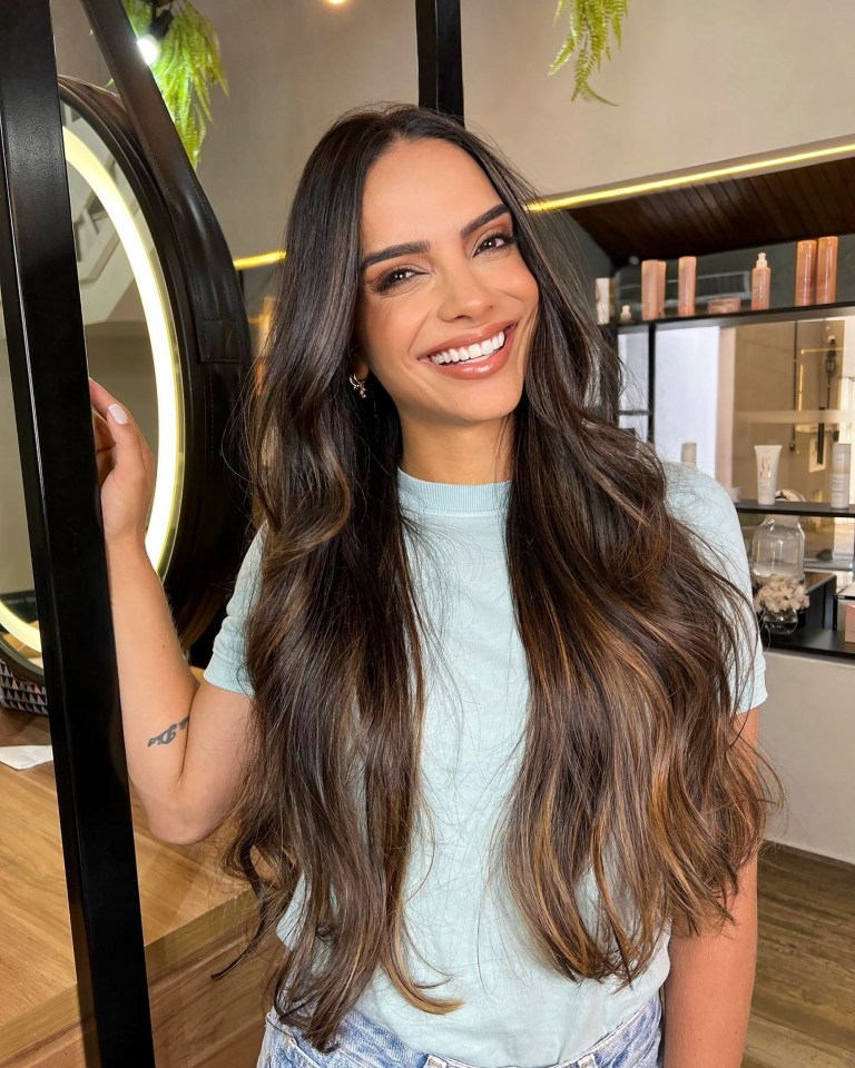 Woman with long brown hair smiling.