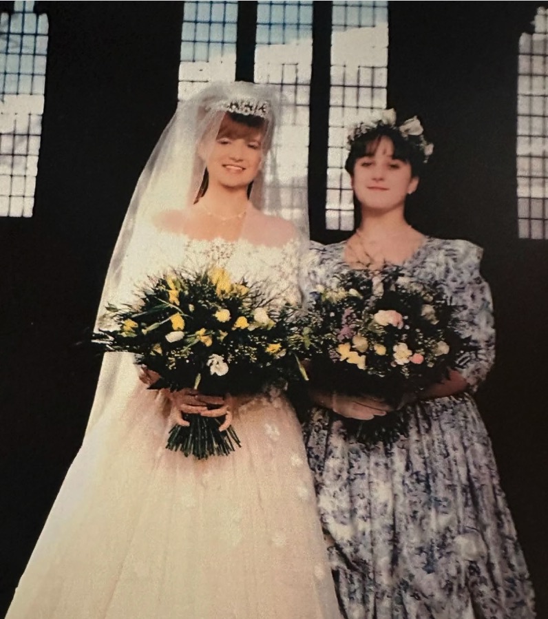 Photo of a bride and bridesmaid at a wedding.