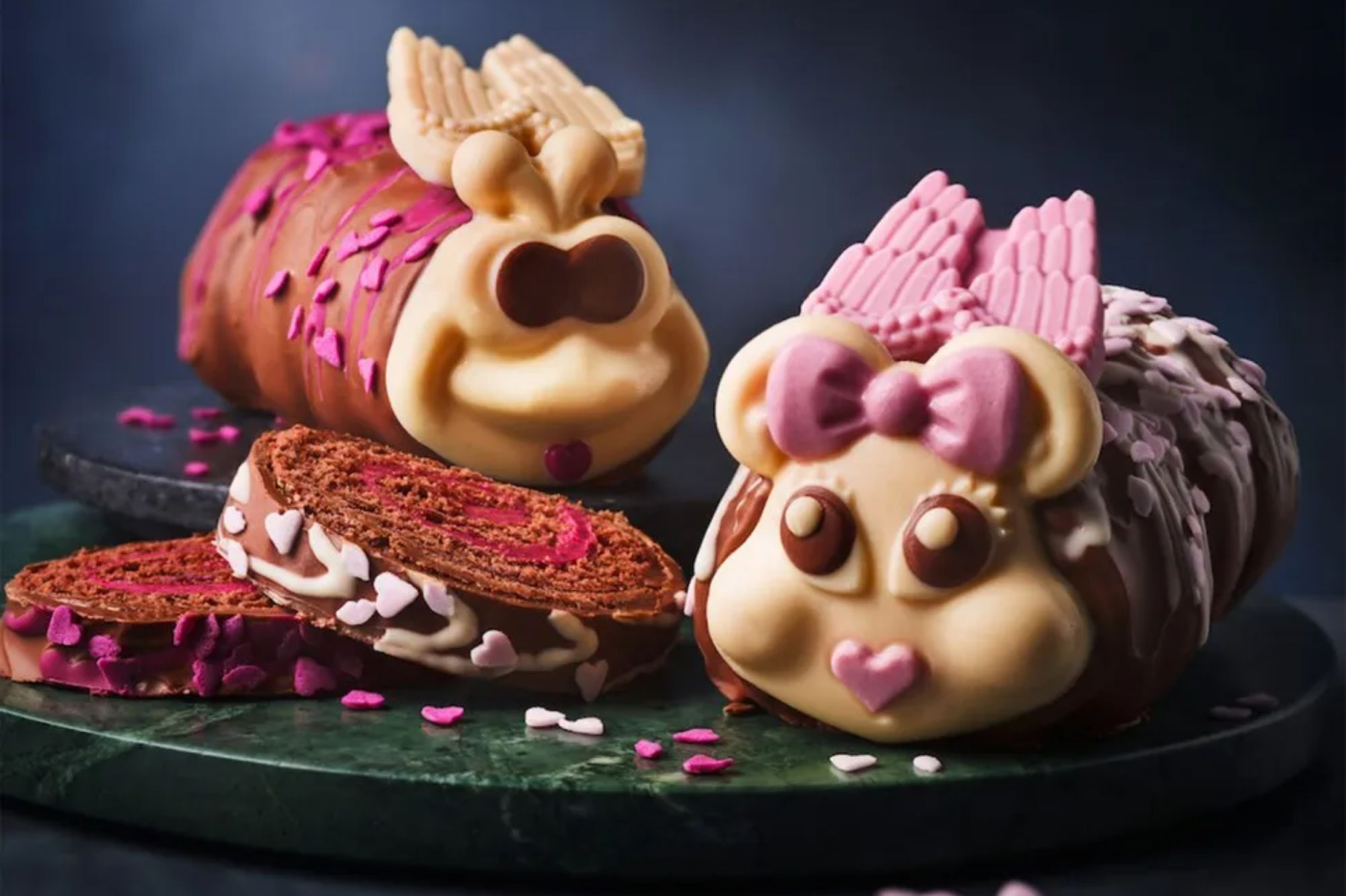 Two chocolate swiss rolls shaped like animals with wings and bows.