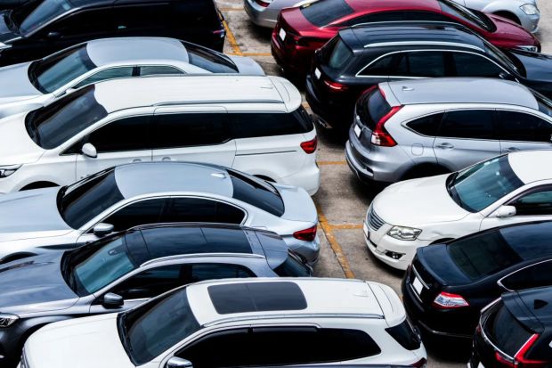 An image collage containing 1 images, Image 1 shows Aerial view of a parking lot full of cars