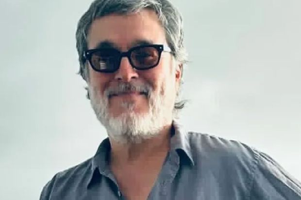 Portrait of a man with graying hair and a beard wearing glasses.