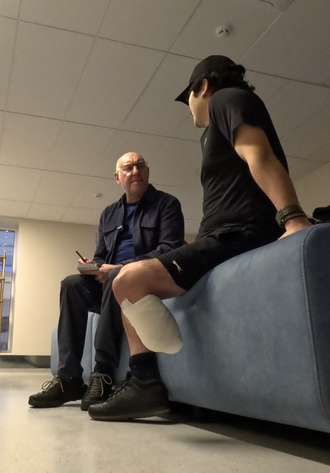 A man with a prosthetic leg speaks with a reporter.