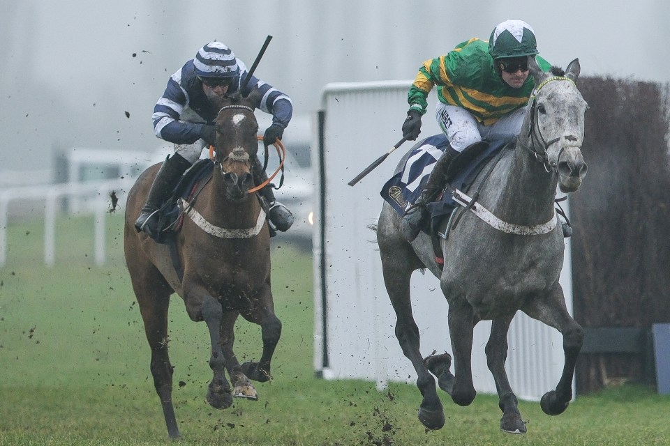 Two jockeys racing horses at Newbury Racecourse.