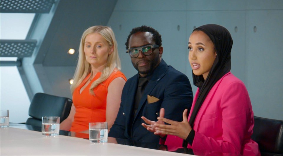 Three people sitting at a table, one woman is speaking.