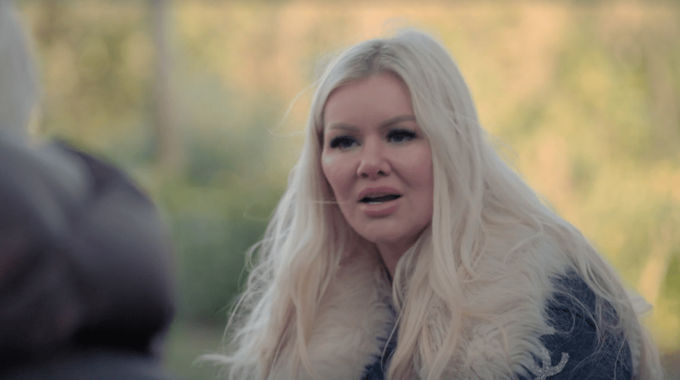 Woman with long blonde hair speaking outdoors.