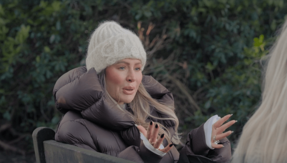 Woman in a puffy jacket and knit hat talking.