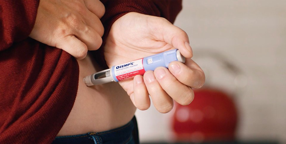 Person injecting Ozempic.