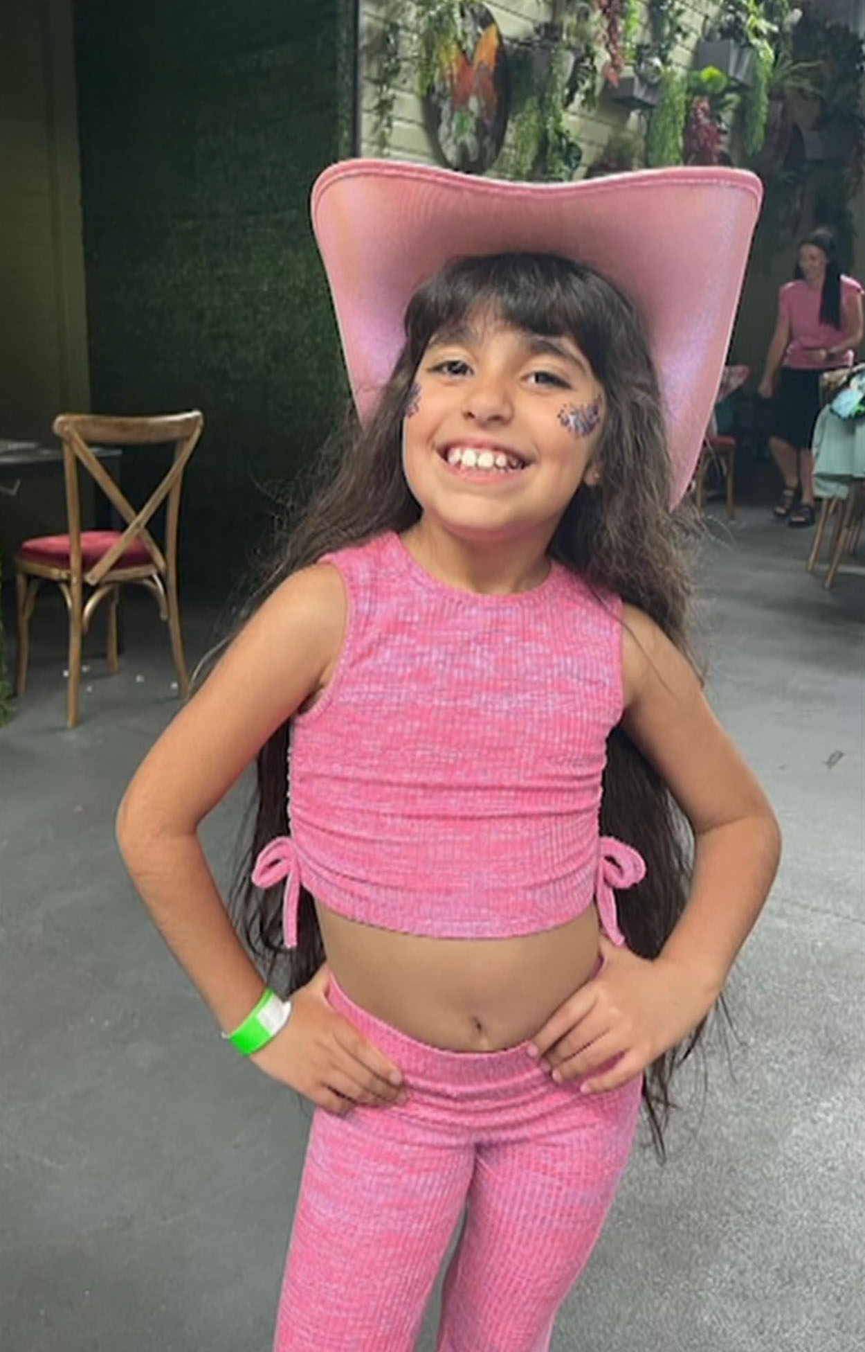 Alice da Silva Aguiar, a young girl wearing a pink cowboy hat and outfit.