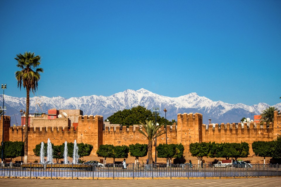 Panoramic view of Taroudant's tower in Morocco, with snow-capped mountains in the background.