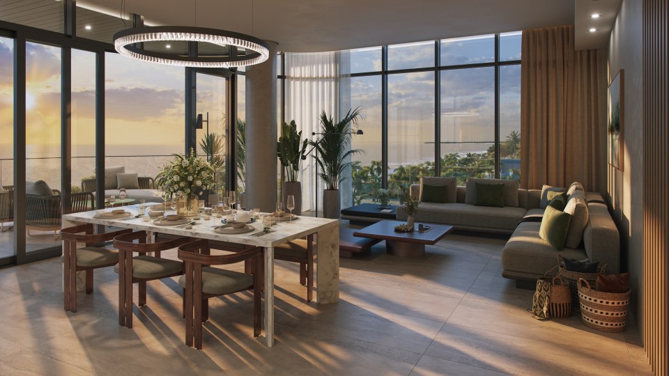 Penthouse living room with ocean view at sunset.