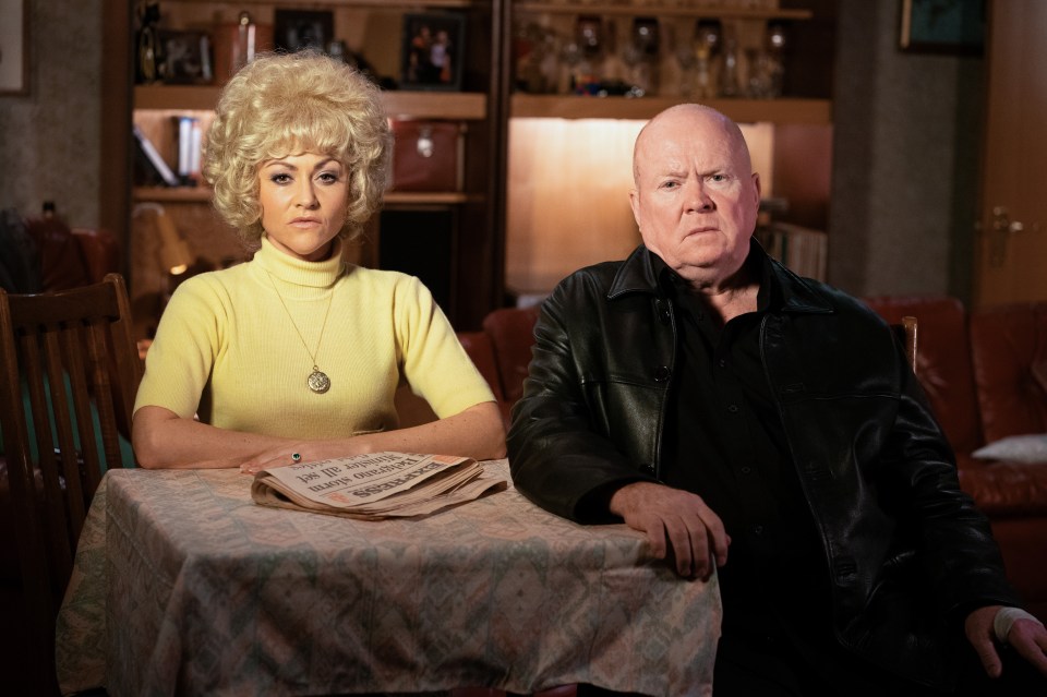 Phil Mitchell and Peggy Mitchell sitting at a table.