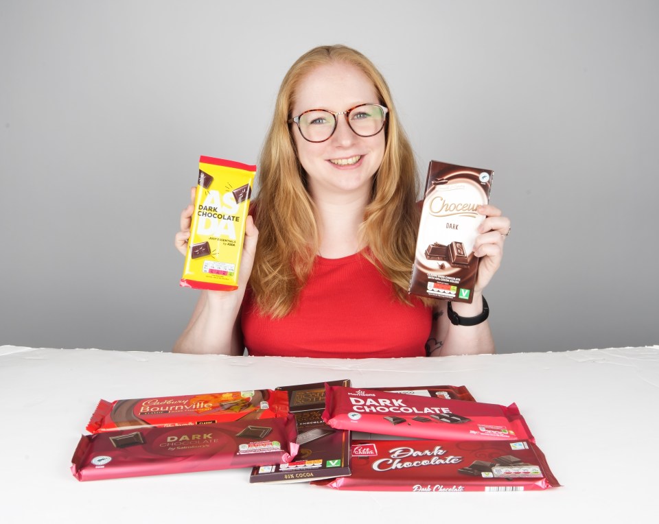 Woman holding various dark chocolate bars.