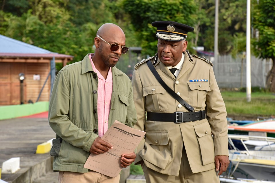 Still image from *Death in Paradise* showing DI Mervin Wilson and Selwyn Patterson.