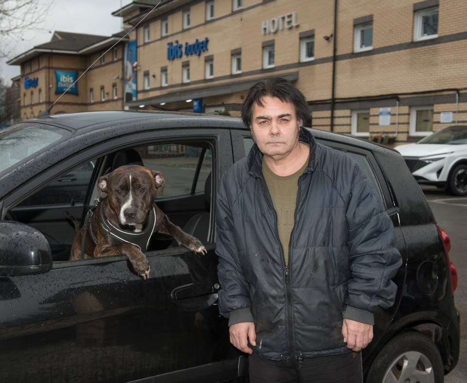 A homeless man and his dog in his car.