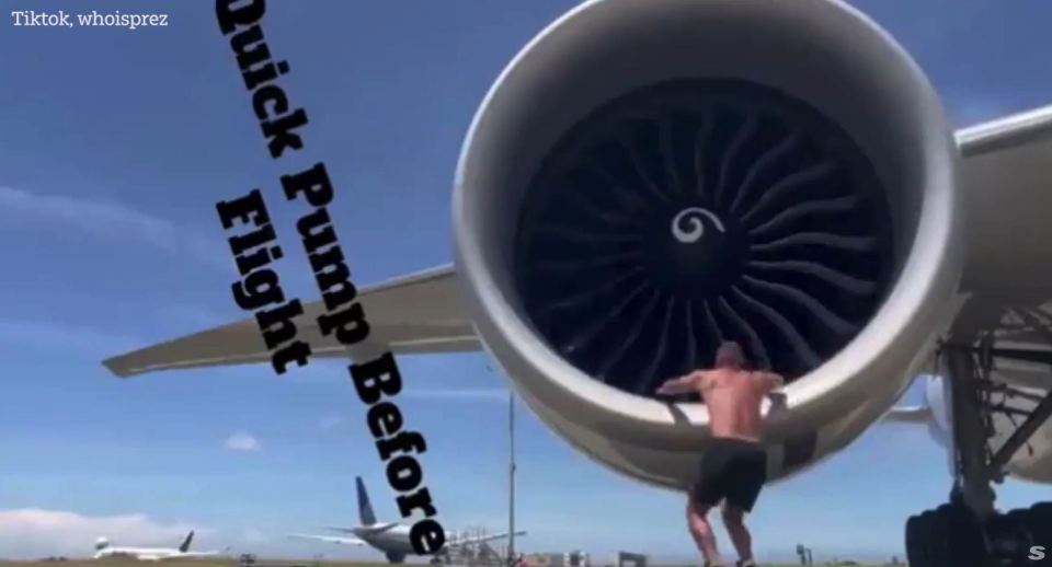 Bodybuilder flexing inside an airplane engine.