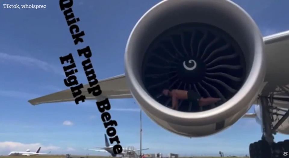 Bodybuilder doing push-ups inside an airplane engine.