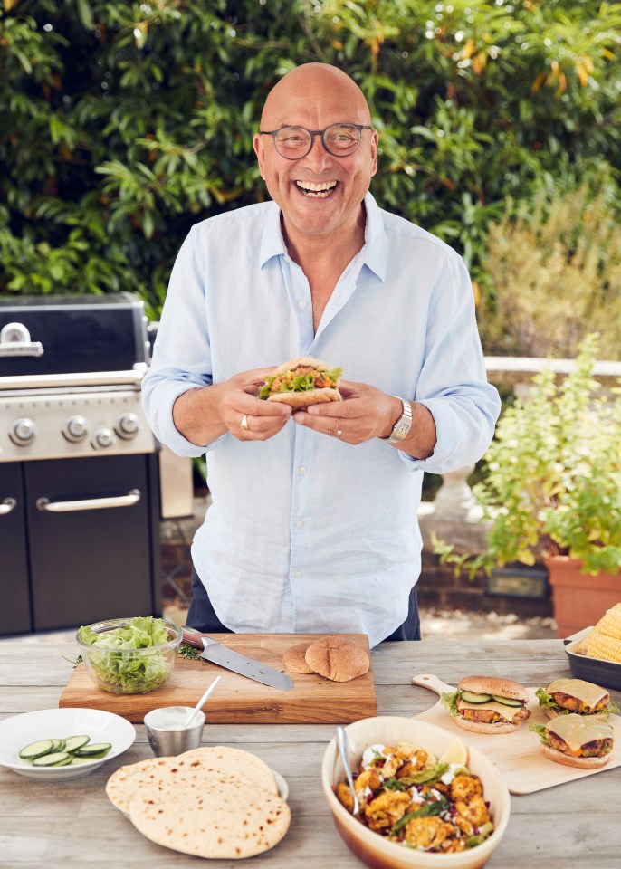 Gregg Wallace holding a barbecue burger outdoors.