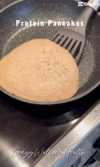 Protein pancake cooking in a pan.