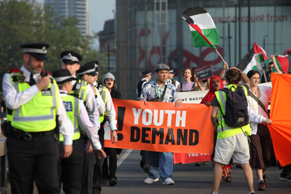 Pro-Palestinian protestors march on Waterloo Bridge carrying a banner that reads "Youth Demand."