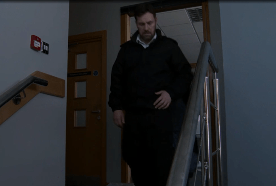 Man in dark jacket descending stairs.