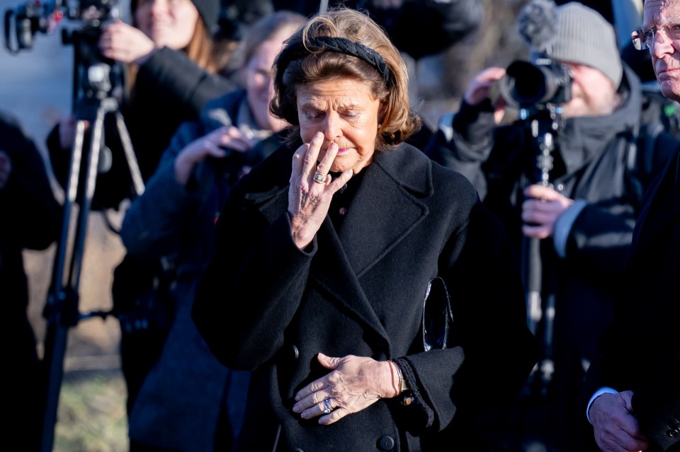 Queen Silvia visibly upset at a school memorial.