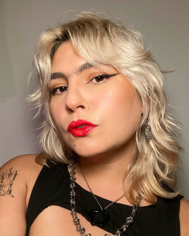 Portrait of a young woman with blonde hair, red lipstick, and a black top.