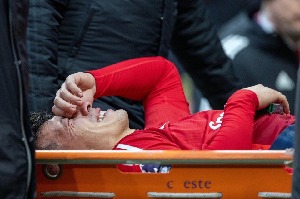 Lisandro Martinez on a stretcher, crying after suffering an apparent injury during a soccer match.