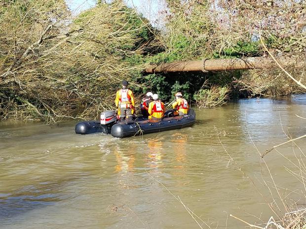 Search and rescue team in a boat on a river.