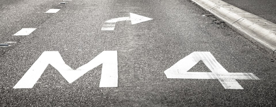 Road marking indicating M4 motorway entrance with right turn arrow.