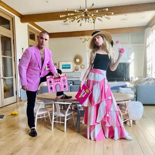 Robbie Williams and Ayda Field in matching pink outfits playing with their children.