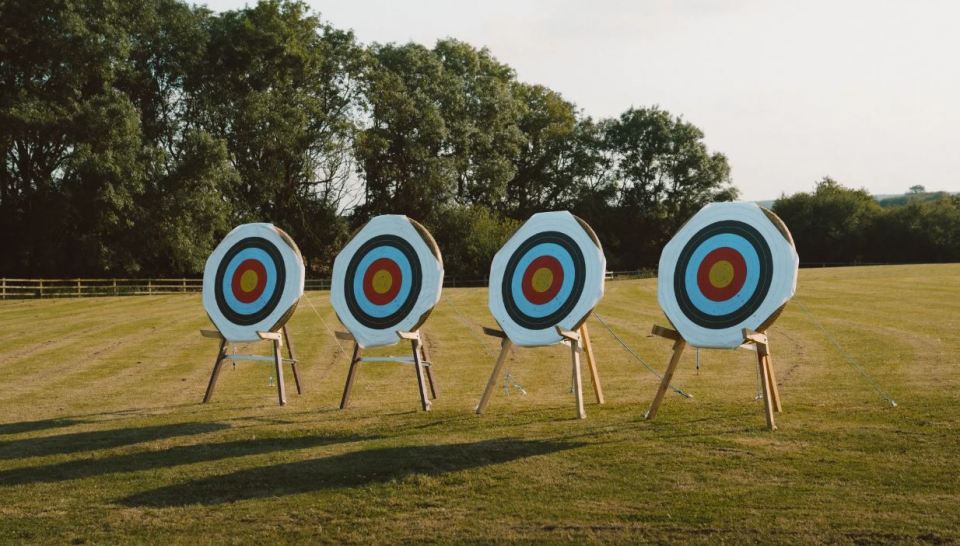 Four archery targets in a field.