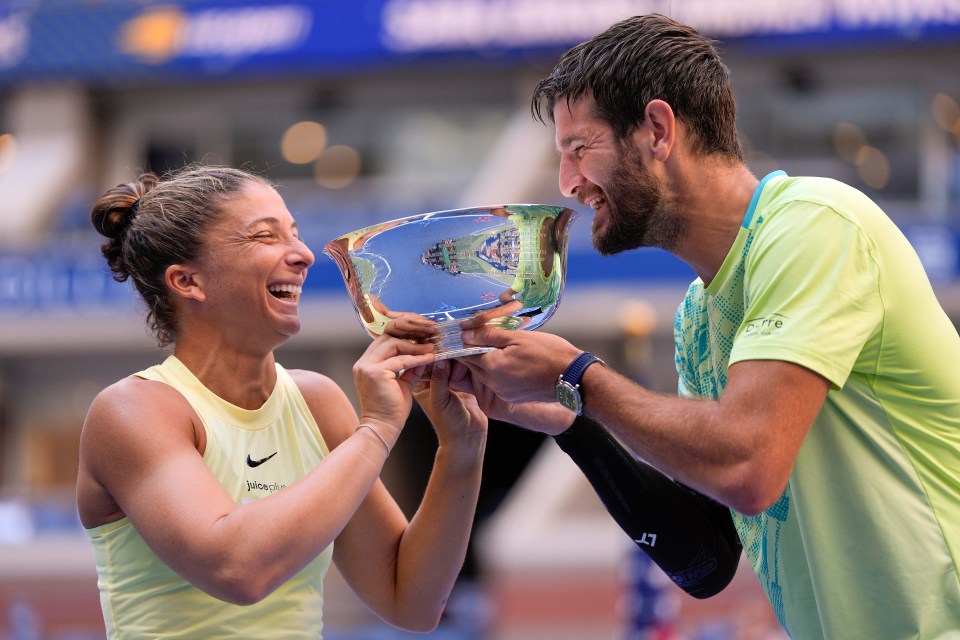 Sara Errani and Andrea Vavassori holding a championship trophy.