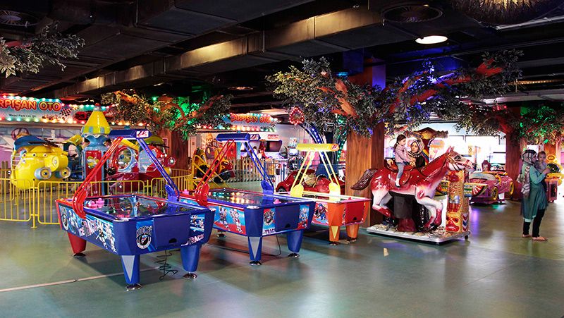 Interior view of Playland Amusement Park in Sarajevo, showing various arcade games and rides.